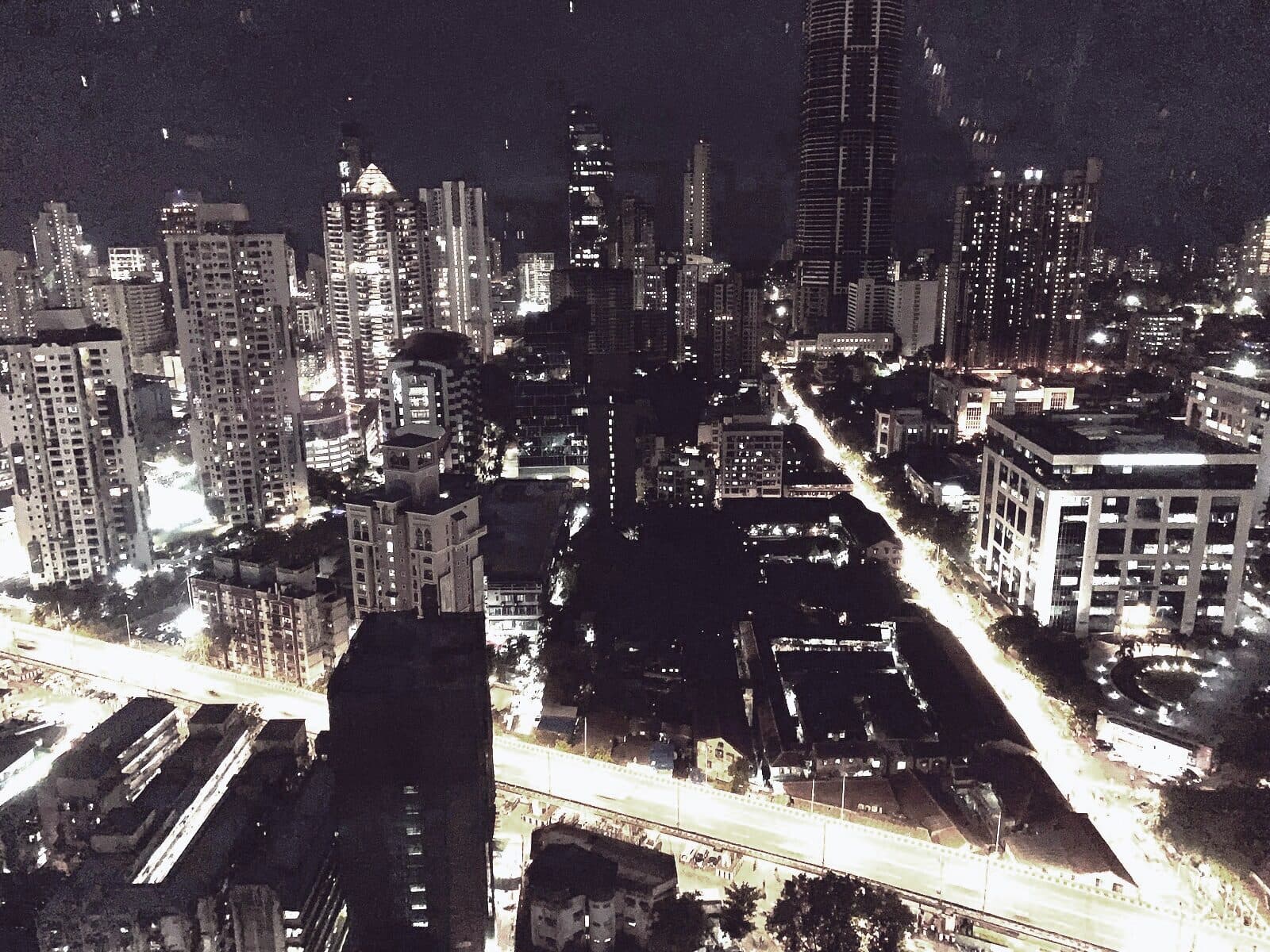 An Indian city seen from above at night, arterial roads picked out in light